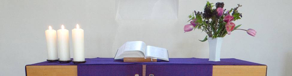 Bild Altar mit drei Kerzen, der Bibel und einem Blumenstrauß